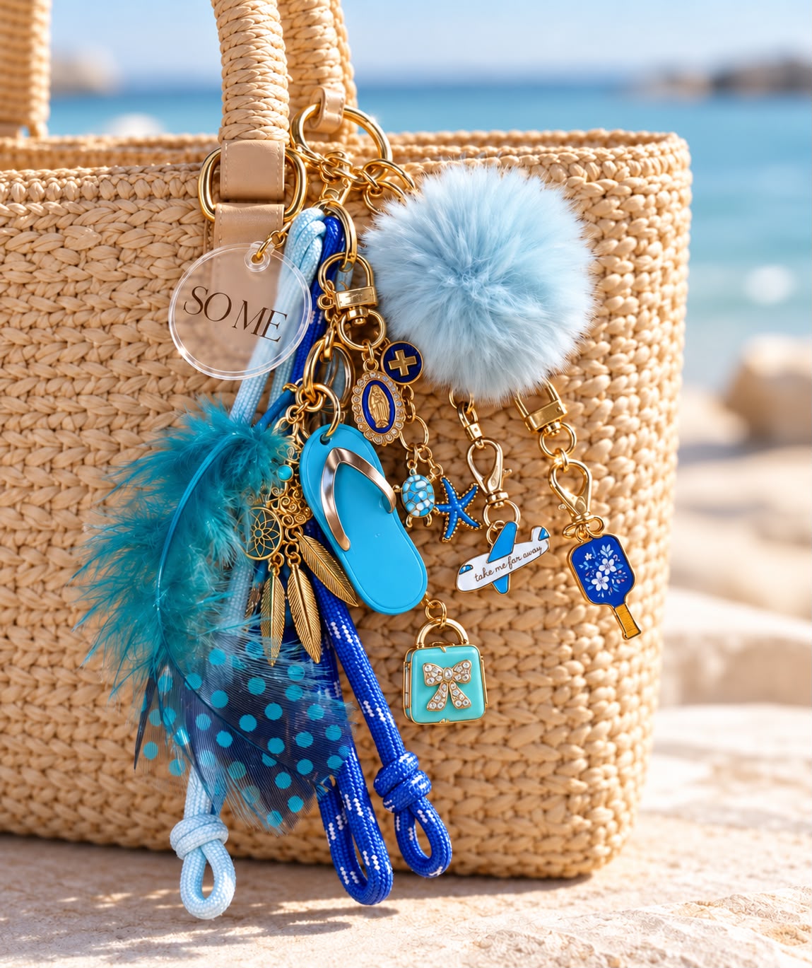 Bolsa de palha na praia com charms azuis: pompom azul, penas turquesa, chinelo azul, tartaruga, avião e pingente